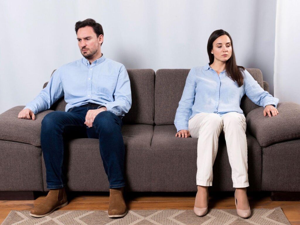 A man and a woman sitting on a couch after divorce.