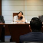 A man sitting in front of judges in a divorce process.