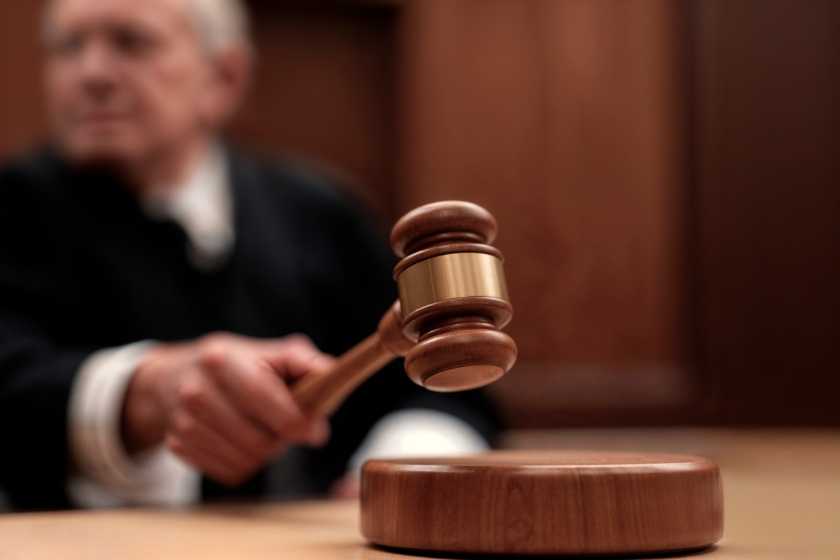 A judge holding a gavel in a courtroom.